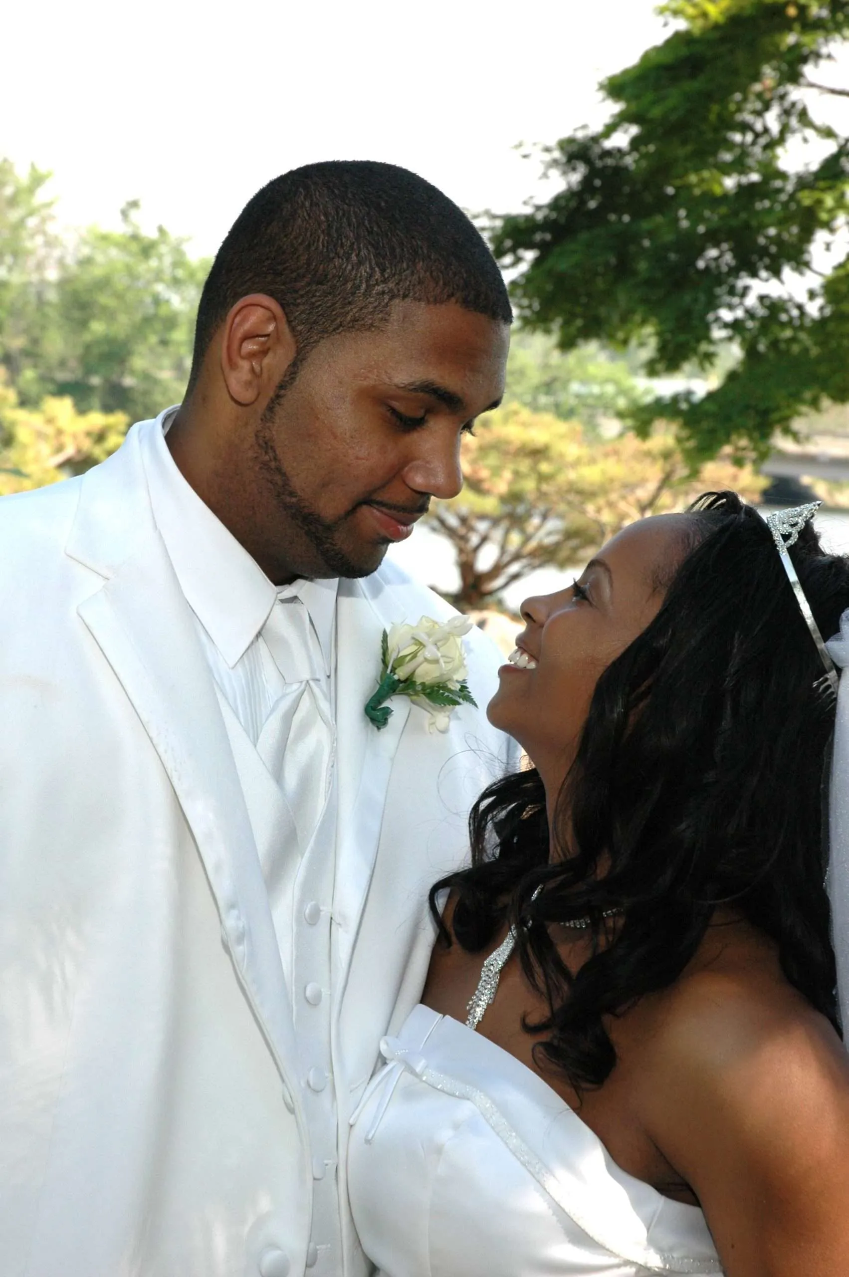 Groom in a white tuxedo with his bride